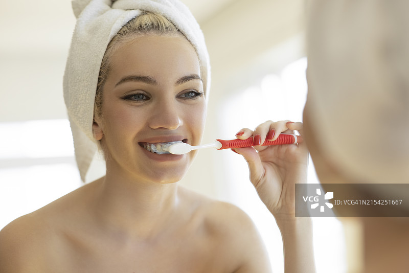 女人用牙刷刷牙并照镜子图片素材