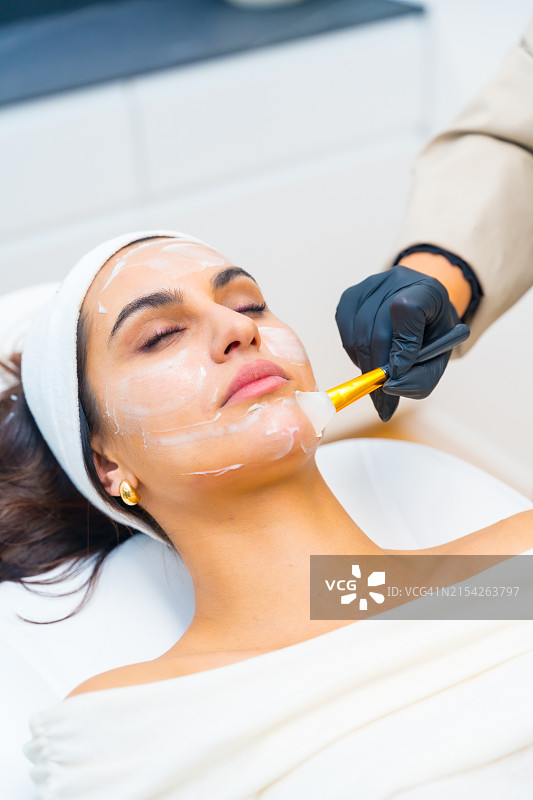 女人接受面部美容霜护理图片素材