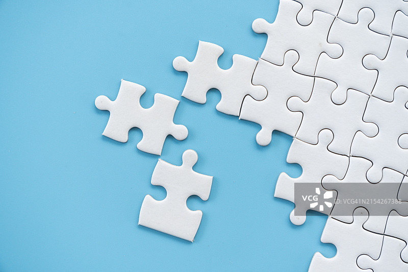 蓝色背景上的白色拼图图片素材
