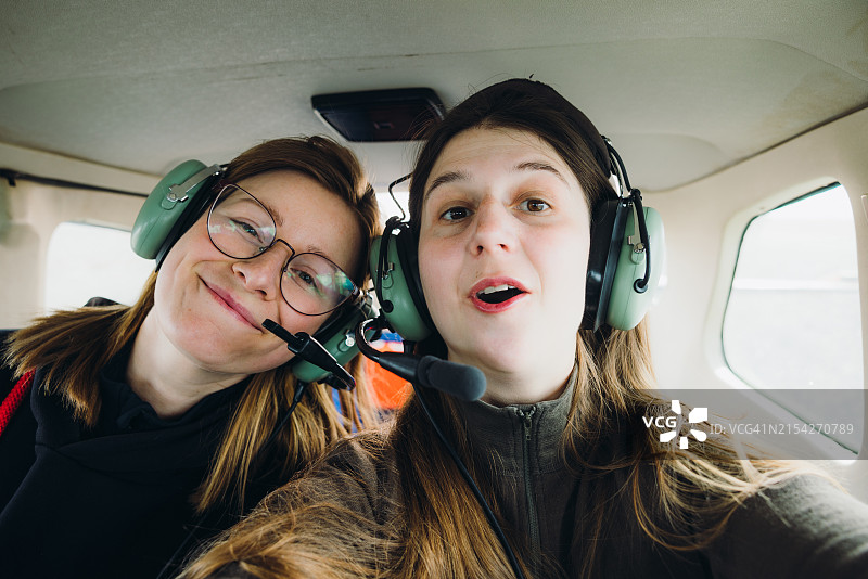两名快乐的女人在小型飞机驾驶舱自拍图片素材