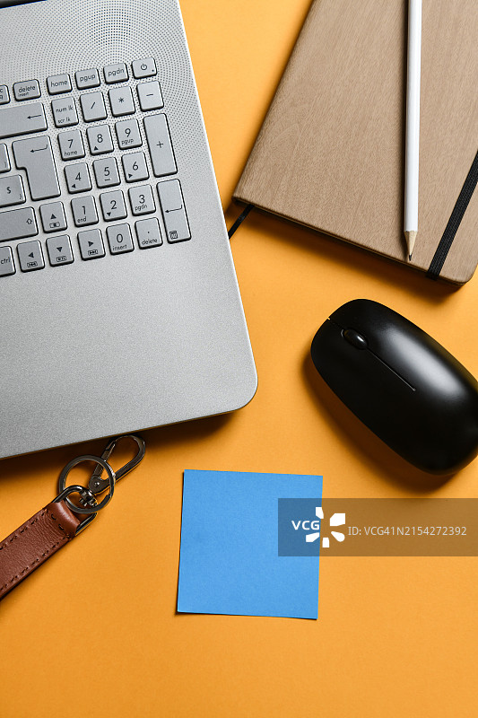 办公必备品：蓝色便利贴、笔记本电脑、鼠标和笔记本图片素材