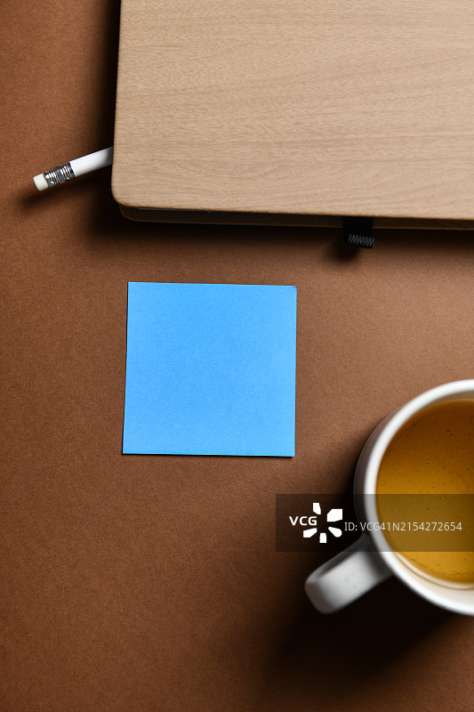 在优质咖啡的推动下，蓝色备忘录在一片空白页中的自我提醒图片素材