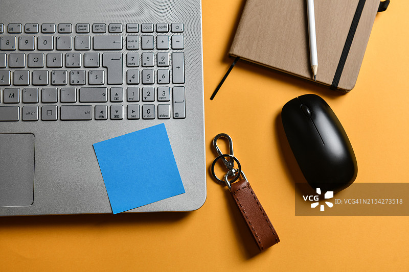 笔记本电脑上的蓝色便签与鼠标和铅笔图片素材