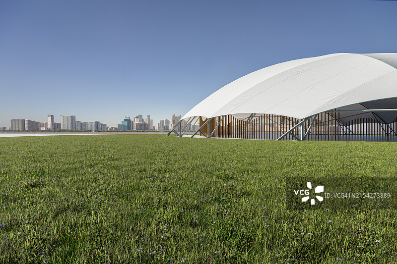 城市天际线下绿茵草坪上的活动帐篷图片素材