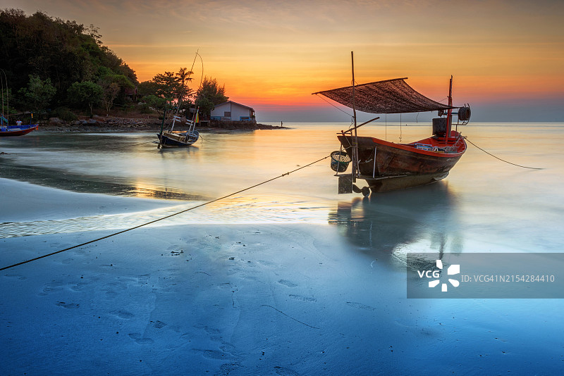 泰国罗勇 - 2021年1月：海景摄影师在泰国罗勇日落时拍摄海滩上渔船的照片图片素材