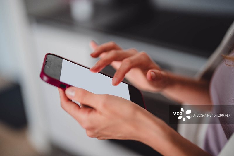 女人拿着显示指南针的手机，桌子上铺着工作文件，室内设计师制定装饰方案，风水图片素材