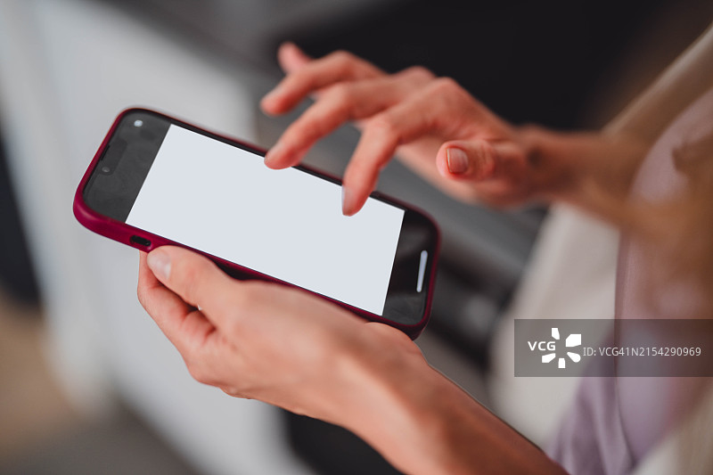 女人拿着显示指南针的手机，桌子上铺着工作文件，室内设计师制定装饰方案，风水图片素材