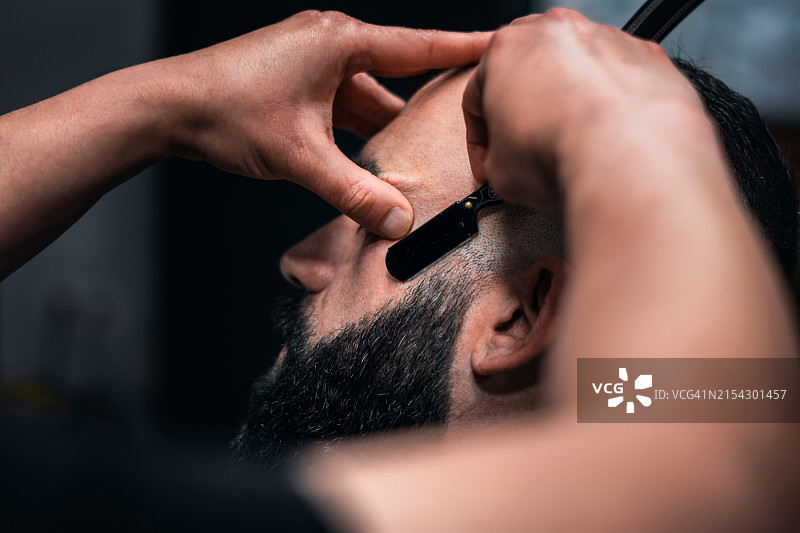 理发师在沙龙里为男人理发的特写镜头图片素材