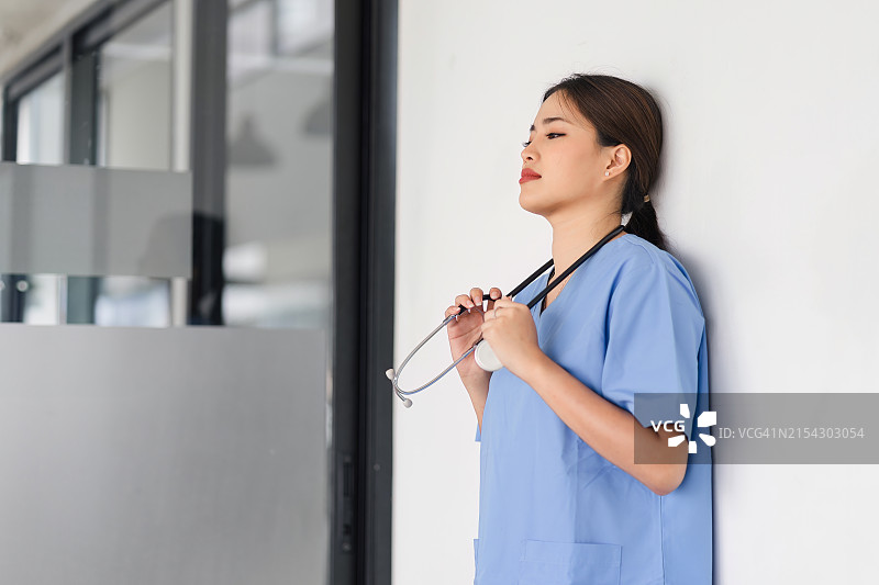 护士靠墙站立的侧视图图片素材