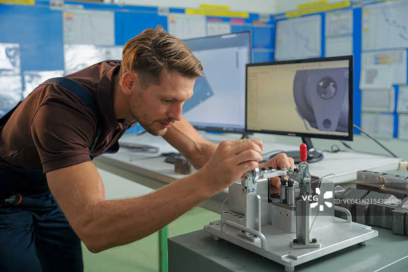 设计工程师检查自动数控机床的夹具量规与CAD设计数据的比较图片素材