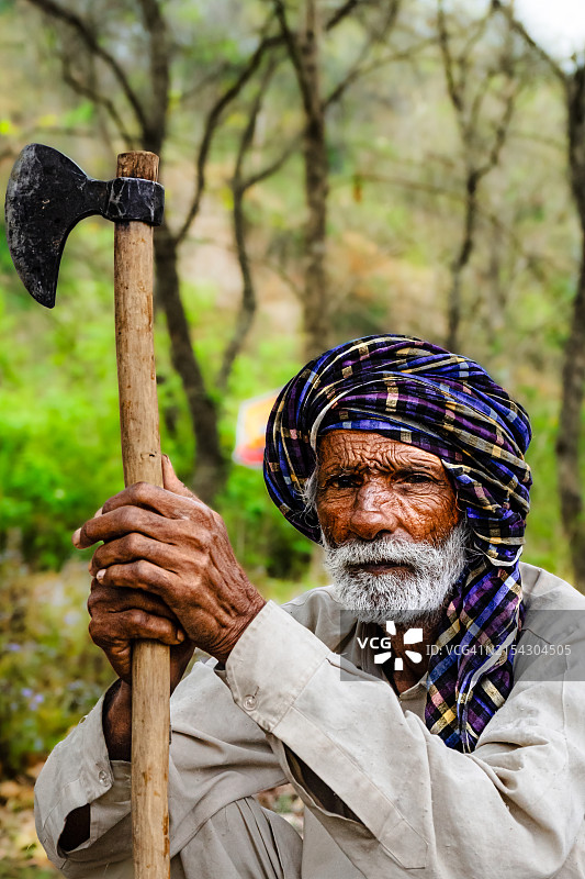 手持斧子的年长男人，印度昌迪加尔图片素材