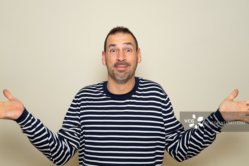 靠墙做手势的男子肖像图片素材