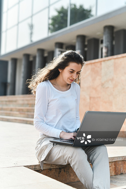 在市中心用笔记本电脑工作的女网页设计师图片素材