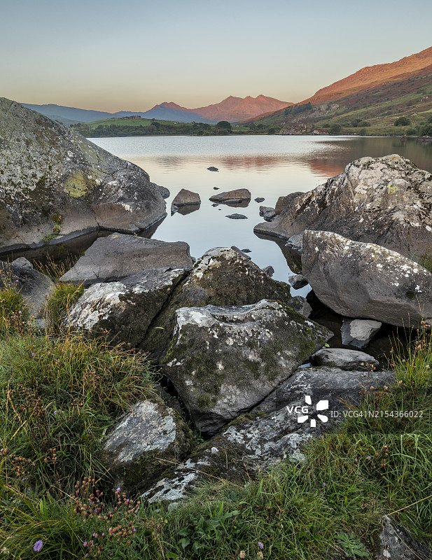 日出时分的岩石和湖泊——英国斯诺多尼亚国家公园图片素材
