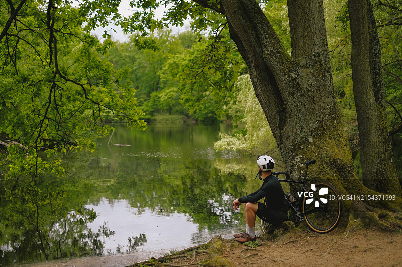 骑自行车的人在森林湖边休息图片素材