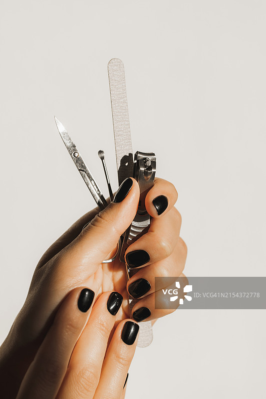 女人手持美甲和修脚工具，对比背景图片素材