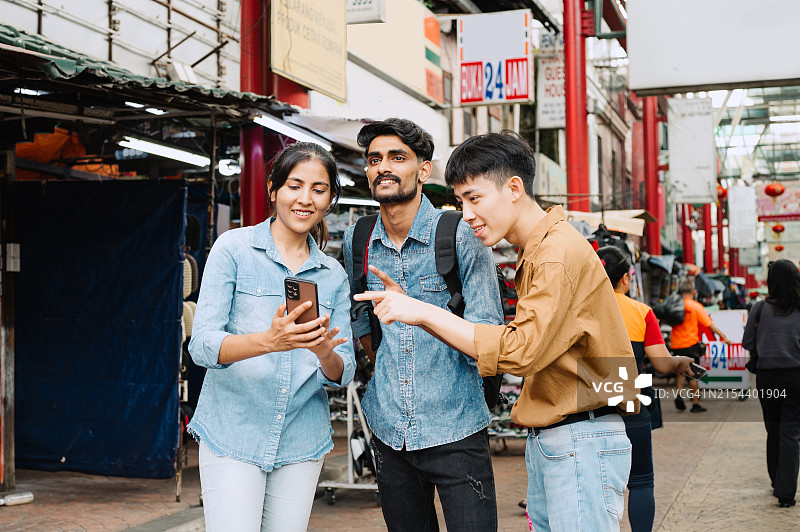 在马来西亚看手机的多种族亚洲游客图片素材