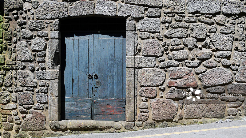葡萄牙波尔图：带风化蓝色木门的旧石墙仓库特写图片素材