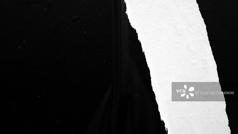 特写：巴黎墙上破损的黑白海报，自然光图片素材