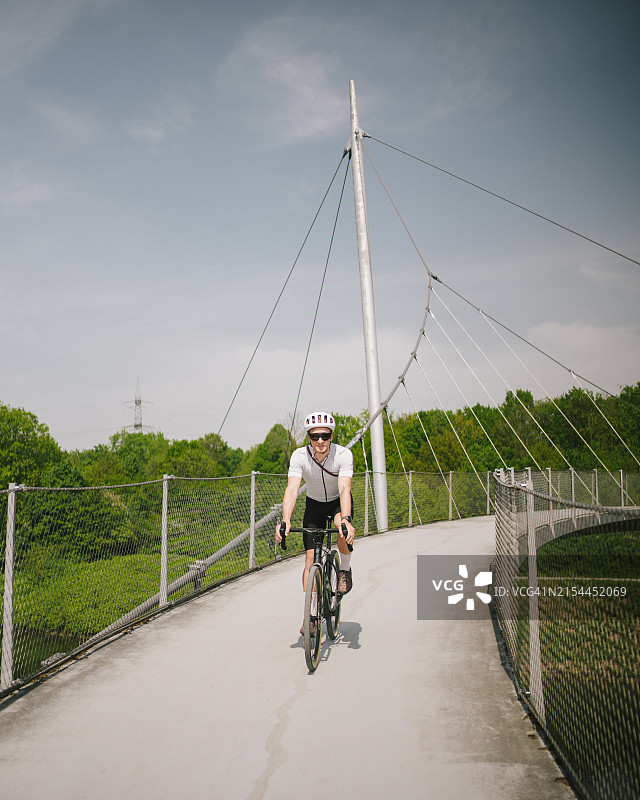 骑自行车的人骑过吊桥图片素材