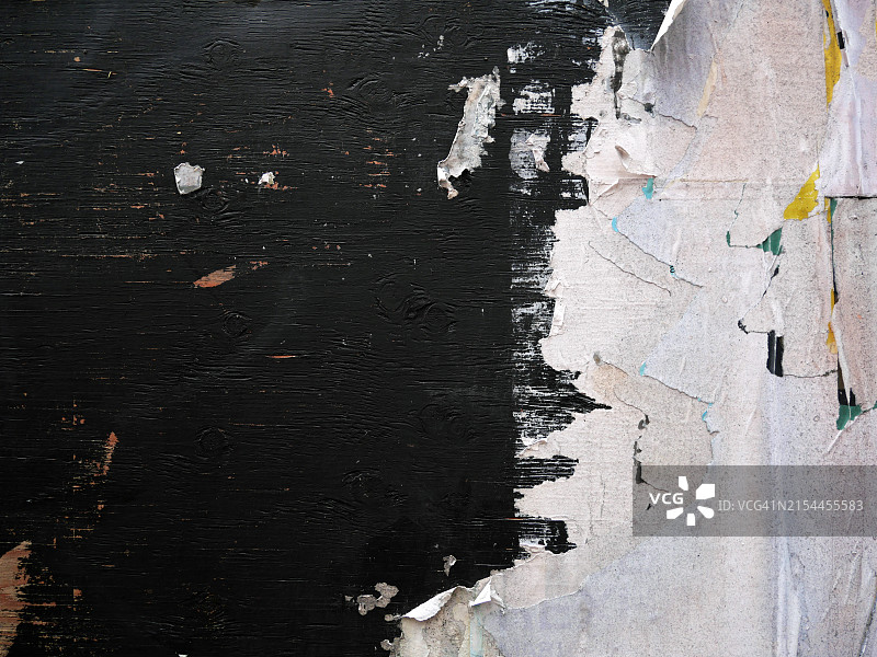 黑色木板上粘贴和撕毁的白皮书,粗糙纹理,加拿大魁北克蒙特利尔建筑工地边界的特写,自然光和色彩图片素材