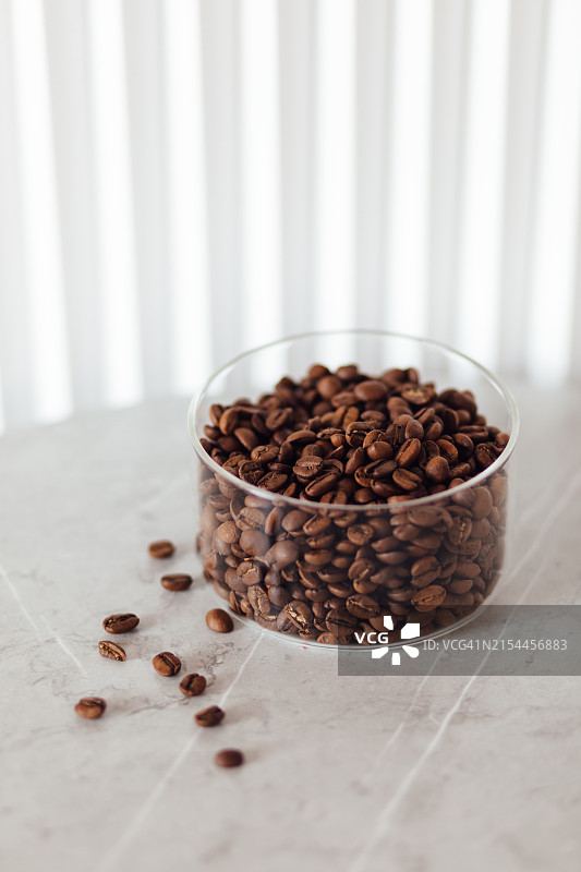 桌子上透明罐子里的咖啡豆特写图片素材