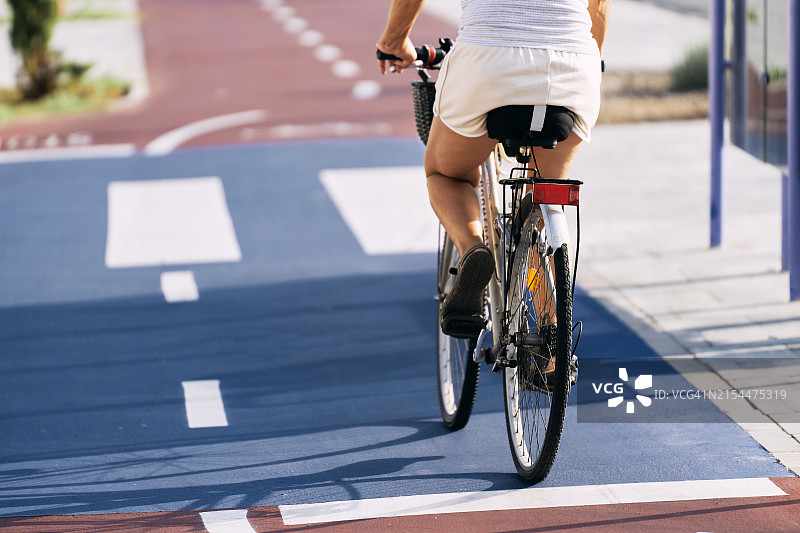 女子在城市街道骑自行车的背影图片素材