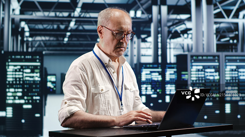 资深工程师使用笔记本电脑工作图片素材