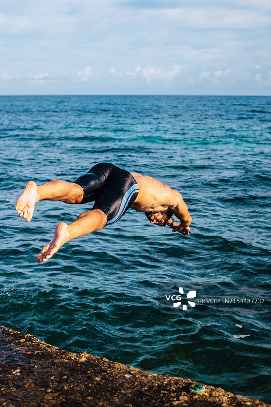 男子在海中对着天空跳跃图片素材