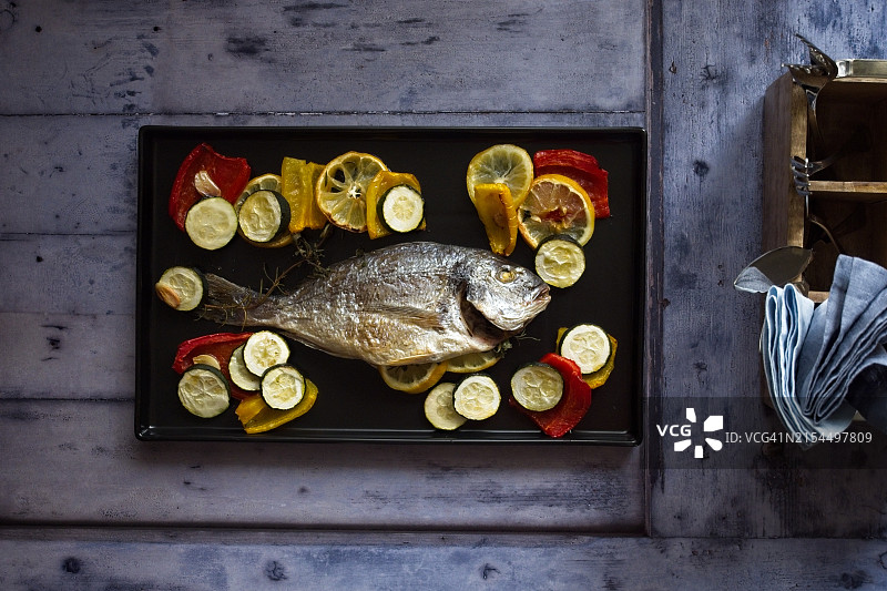 桌子上带有柠檬片的海鲷俯视图图片素材