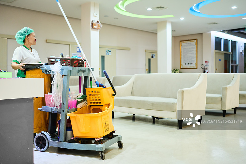 清洁工推着清洁车走过医院走廊图片素材