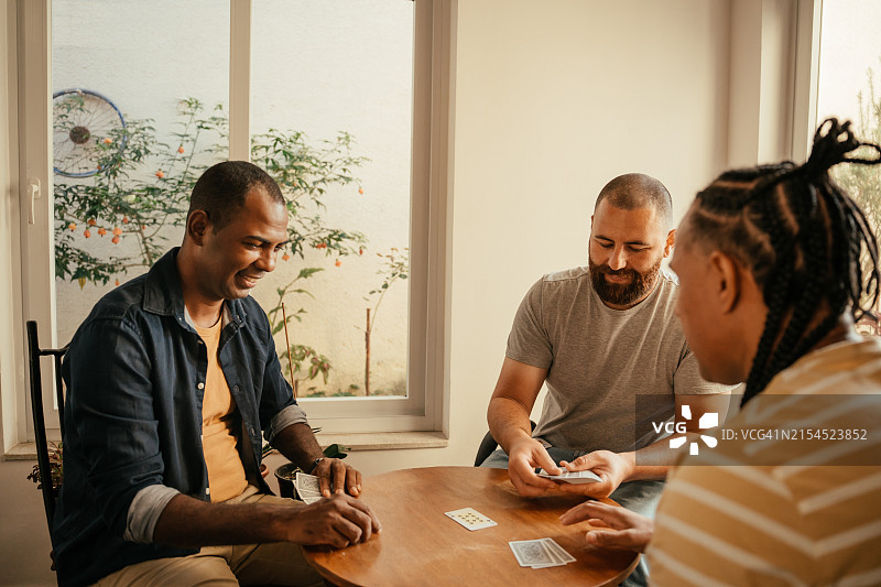 三个朋友玩纸牌游戏图片素材