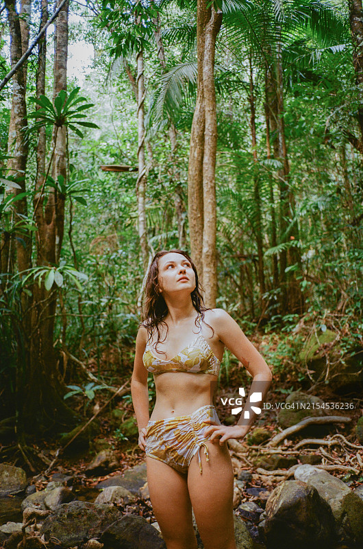游泳后，女人敬畏地看着热带丛林图片素材