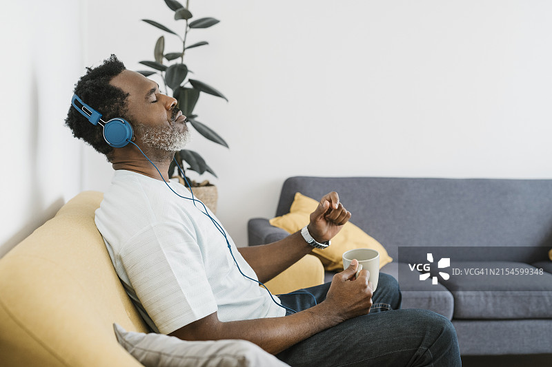 在家听音乐，享受咖啡的非洲男人图片素材