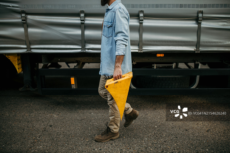 卡车司机放置轮胎挡块以确保安全图片素材