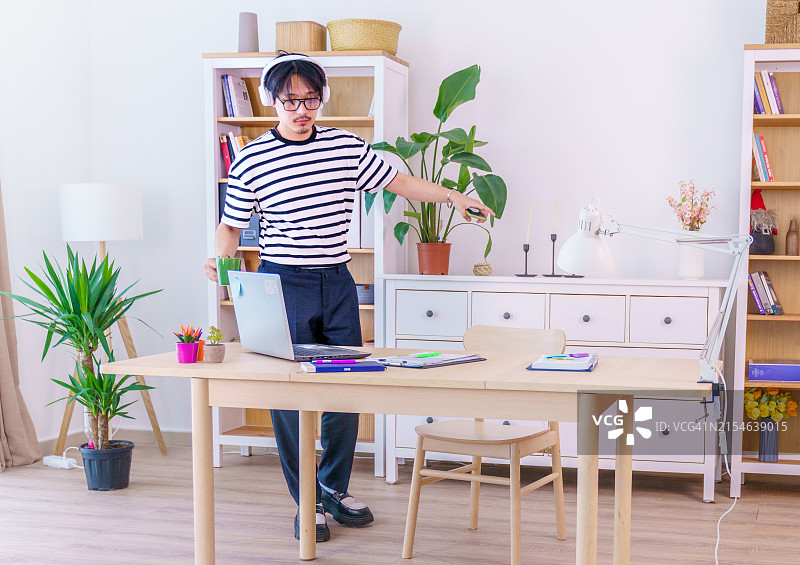 年轻男子身穿条纹衬衫，热情庆祝图片素材