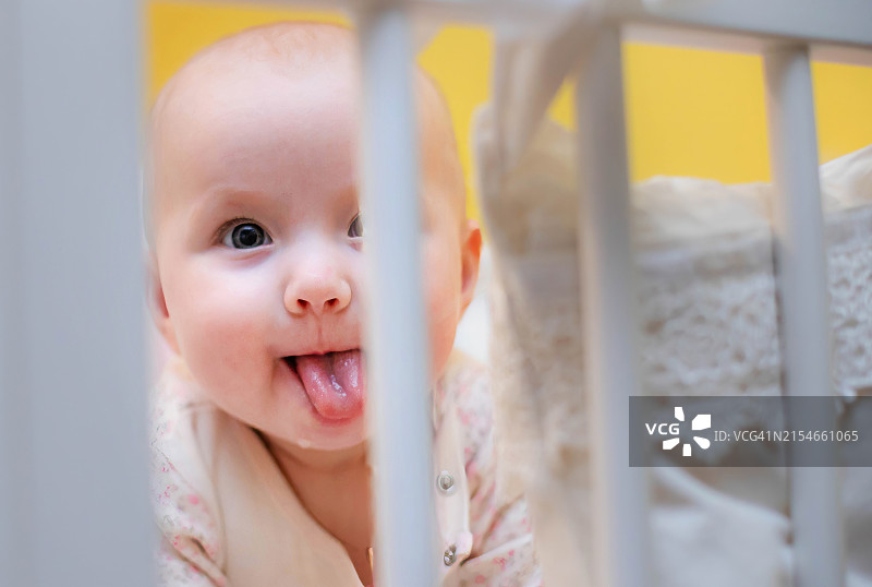 婴儿在婴儿床里吐舌头图片素材