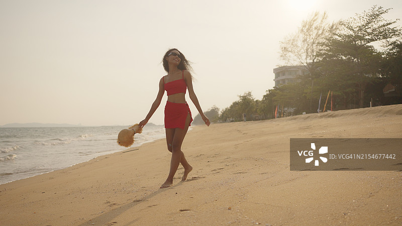 在海滩上行走的快乐的非裔美国妇女图片素材