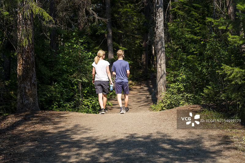 母亲和儿子在加拿大不列颠哥伦比亚省的森林里徒步旅行图片素材