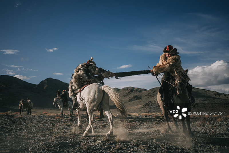 蒙古巴彦洪格尔省两名哈萨克族猎鹰人参加骑马叼羊比赛图片素材