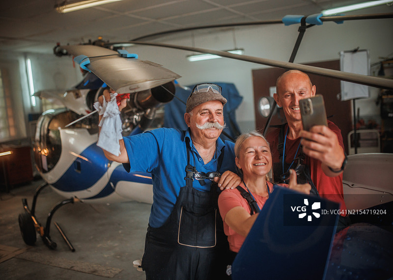 快乐的人们坐在直升机旁图片素材