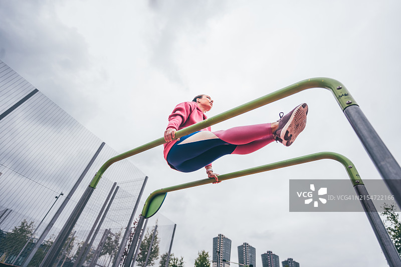在公园里做引体向上的运动型女人图片素材