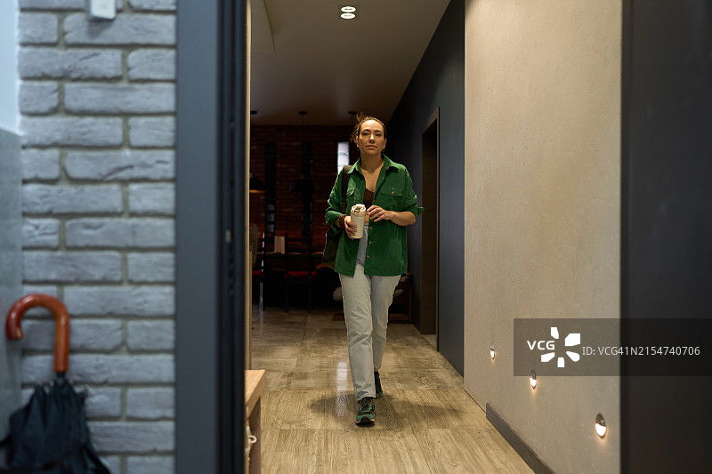 穿过现代住宅走廊的女人图片素材
