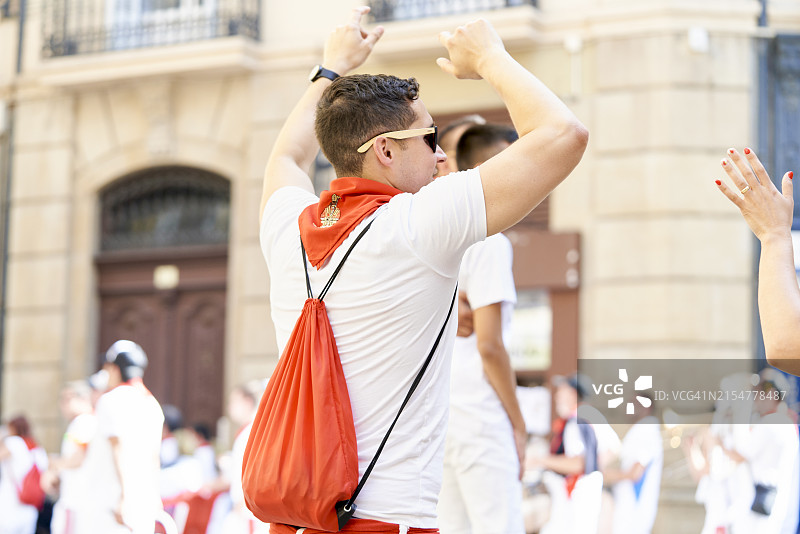 在西班牙潘普洛纳圣费尔明节的庆祝活动中，人们在街上随着传统音乐管弦乐队的演奏跳舞图片素材