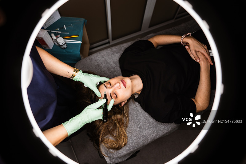 女人在美容水疗中心接受超声波和激光面部护理图片素材