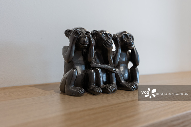 架子上捂着嘴、眼睛和耳朵的猴子雕像图片素材