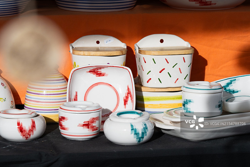 市场摊位上色彩鲜艳的陶器和家居用品图片素材