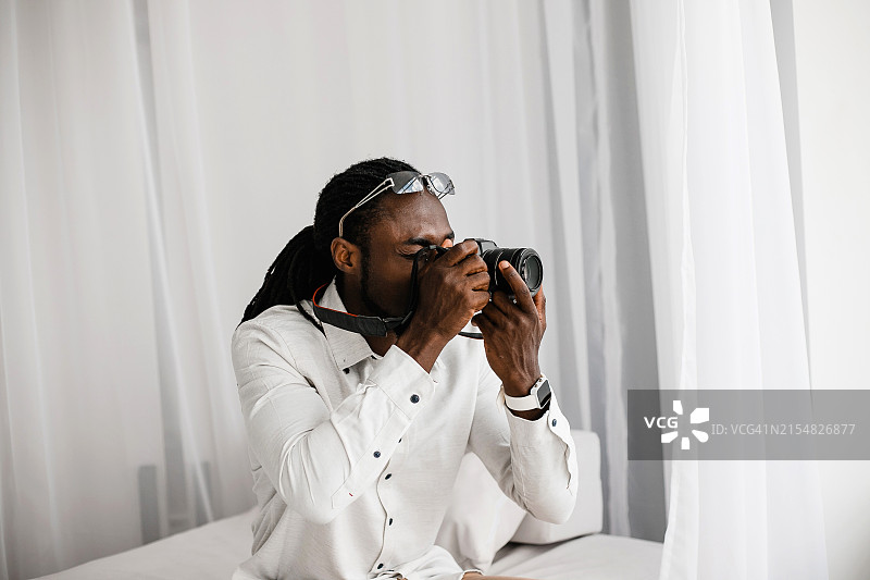 用专业相机拍摄的年轻非裔美国男摄影师图片素材