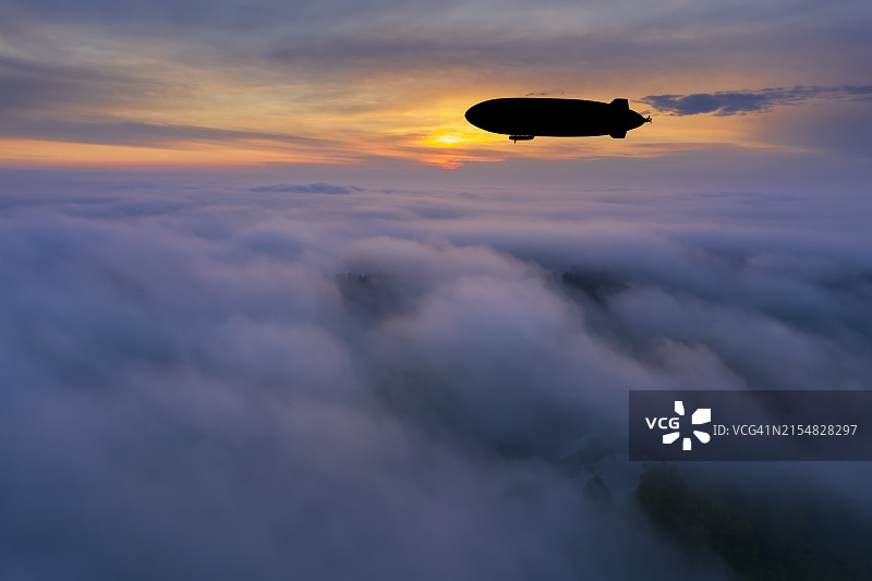 戏剧性日落时分云层之上的飞艇图片素材