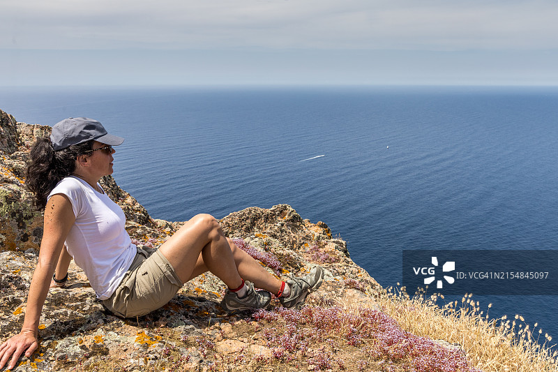 看着波尔图海湾悬崖的女人图片素材